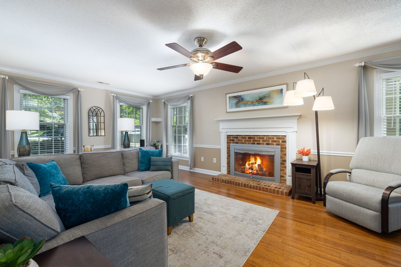 About Inviting living room featuring a cozy fireplace, modern furniture, and bright natural lighting.