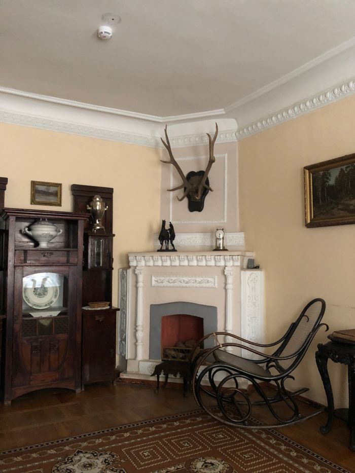 Home Charming vintage room featuring antique furniture, a fireplace, and decorative antlers.